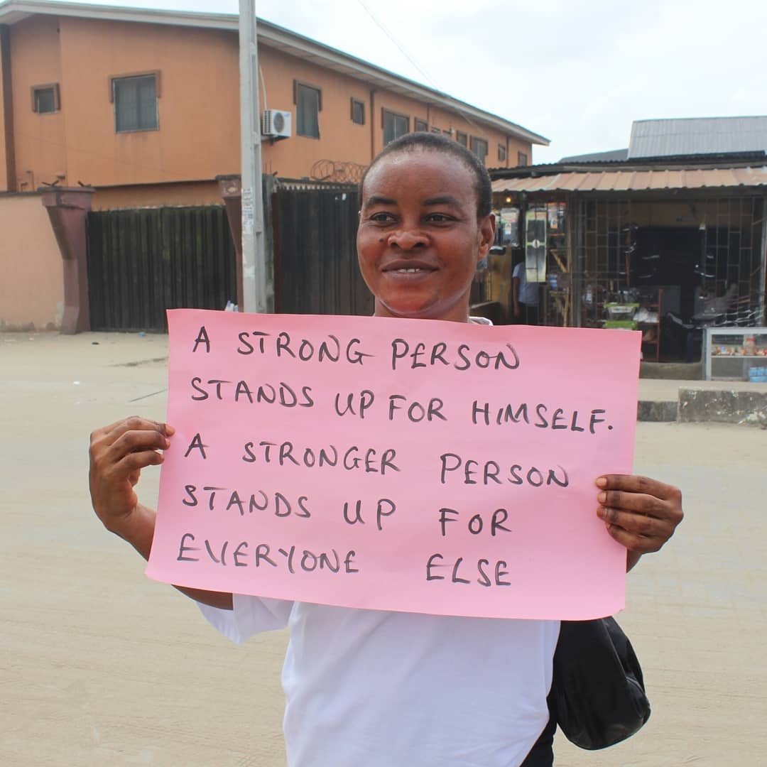 Woman holding a sign about standing up for everyone else